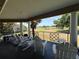 Covered balcony overlooking a scenic golf course and pond with seating provides a relaxing outdoor space at 7320 Westpointe Blvd # 531, Orlando, FL 32835