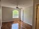 Sunny bedroom featuring hardwood floors, neutral walls, and a large window allowing for natural light at 7320 Westpointe Blvd # 531, Orlando, FL 32835