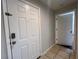 A view of the front door with tiled floor and a glimpse into another room, painted in neutral tones at 7320 Westpointe Blvd # 531, Orlando, FL 32835