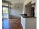 Dining and kitchen area with wood floors and stainless steel appliances, plus a door to the outdoor balcony at 7320 Westpointe Blvd # 531, Orlando, FL 32835