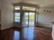 Living area with wood floors, large windows, and sliding glass doors leading to a balcony overlooking a lake at 7320 Westpointe Blvd # 531, Orlando, FL 32835