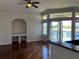 Spacious living room with hardwood floors, built-in shelving, and sliding door to the outside at 7320 Westpointe Blvd # 531, Orlando, FL 32835