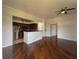 Spacious living area with dark wood flooring, modern ceiling fan, and partial view of the kitchen with stainless appliances at 7320 Westpointe Blvd # 531, Orlando, FL 32835