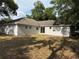 Home's backyard is spacious with mature trees and a sliding glass door entrance at 901 Cascades Park Trl, Deland, FL 32720