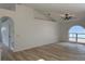 Bright living room with vaulted ceilings, fan and a large arched window letting in natural light at 901 Cascades Park Trl, Deland, FL 32720