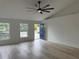 Light-filled living room featuring an oversized ceiling fan and an inviting entry door at 901 Cascades Park Trl, Deland, FL 32720