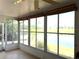 Inviting sunroom with ceiling fan offers panoramic lake views through numerous windows at 904 W Charing Cross Cir, Lake Mary, FL 32746