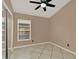 Neutral bedroom features tile floors, ceiling fan, and a closet with sliding doors at 9668 Hollyhill Dr, Orlando, FL 32824