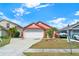 Charming single Gathering home with a well maintained lawn, flowering landscape, and a two car garage at 9668 Hollyhill Dr, Orlando, FL 32824