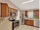 Bright kitchen featuring tile floors, wood cabinets, stainless steel appliances and mosaic tile backsplash at 9668 Hollyhill Dr, Orlando, FL 32824