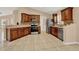 Bright kitchen featuring tile floors, dark wood cabinets, stainless steel appliances and a mosaic backsplash at 9668 Hollyhill Dr, Orlando, FL 32824
