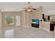 Bright living room featuring tile floors, vaulted ceiling, ceiling fan, open floor plan to kitchen at 9668 Hollyhill Dr, Orlando, FL 32824