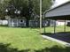 A green backyard featuring two sheds in matching colors at 1010 Dakota Ave, St Cloud, FL 34769