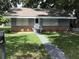 Charming single-story home featuring a well-manicured lawn, a classic brick foundation, and freshly-planted greenery at 1010 Dakota Ave, St Cloud, FL 34769