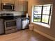Bright kitchen featuring stainless steel appliances, gray cabinets, a window seat, and new wood flooring at 1010 Dakota Ave, St Cloud, FL 34769