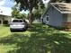 Spacious side yard with green grass surrounding the house and additional detached storage on the property at 1010 Dakota Ave, St Cloud, FL 34769