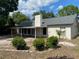 Back exterior of house showing neutral stucco, a grey roof and bushes in the back yard at 1011 Chance Cv, Oviedo, FL 32765
