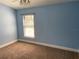 A basic bedroom with blue walls, neutral carpet, and a window at 1011 Chance Cv, Oviedo, FL 32765