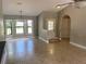 Bright living room showcasing tiled floors and large windows inviting ample natural light with a light-colored front door at 1011 Chance Cv, Oviedo, FL 32765