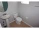 Compact half-bathroom with toilet, pedestal sink, neutral walls, and tile flooring at 1034 Enclair St, Orlando, FL 32828