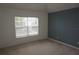 Simple bedroom with neutral carpet, a window for natural light, and painted accent wall at 1034 Enclair St, Orlando, FL 32828