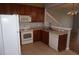 Kitchen featuring white appliances, wood cabinets, tile flooring, and a breakfast bar at 1034 Enclair St, Orlando, FL 32828