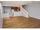 Open-concept living area with wood floors, stairs, chandelier, and seamless transition to kitchen at 1034 Enclair St, Orlando, FL 32828