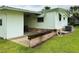 Rear of light green home with carport and adjacent brick planter at 106 Azalea Trl, Leesburg, FL 34748