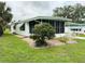 Light green home featuring a large screened-in porch at 106 Azalea Trl, Leesburg, FL 34748