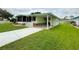 Well-manicured light green house with carport and concrete driveway at 106 Azalea Trl, Leesburg, FL 34748