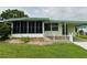 Charming light green home with screened porch and adjacent carport at 106 Azalea Trl, Leesburg, FL 34748
