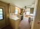 Compact kitchen with wood cabinetry, white countertops, and appliances at 106 Azalea Trl, Leesburg, FL 34748