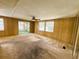 Living room with a ceiling fan, wood paneling, an open floor plan, and sliding glass doors at 106 Azalea Trl, Leesburg, FL 34748
