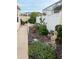Landscaped backyard featuring lush garden beds, a charming statue, and pathway lights at 1130 Pelion Pl, The Villages, FL 32162