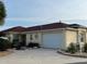 Inviting single-story home featuring a well-manicured lawn, a two-car garage, and a beautifully landscaped front yard at 1130 Pelion Pl, The Villages, FL 32162