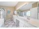 Bright bathroom with double vanity, large mirror, glass-enclosed shower, and soaking tub at 115 Henue Ct, Davenport, FL 33896