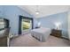 Cozy bedroom featuring blue walls, ceiling fan, plush carpet, and a scenic window view at 115 Henue Ct, Davenport, FL 33896