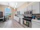 Bright kitchen features stainless steel appliances, tile backsplash, eat-in nook and backyard views at 115 Henue Ct, Davenport, FL 33896