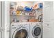 Practical laundry room equipped with modern washer and dryer units and convenient shelving at 115 Henue Ct, Davenport, FL 33896