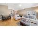 Spacious living room with wood floors, ceiling fan, a glimpse of the kitchen and a comfortable seating area at 115 Henue Ct, Davenport, FL 33896
