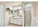 Bright bathroom with double sinks, a large mirror, and a glass-enclosed shower for added convenience at 130 Evergreen Dr, Auburndale, FL 33823