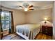 Comfortable bedroom features a ceiling fan, window with blinds, and warm decor at 130 Evergreen Dr, Auburndale, FL 33823