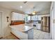 Bright kitchen featuring white cabinetry, stainless steel appliances, and a breakfast bar at 130 Evergreen Dr, Auburndale, FL 33823