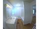 Bathroom featuring a single sink vanity, a mirror with vanity lighting, and a shower-tub combo at 15 Ne 63Rd Ct, Ocala, FL 34470