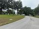 Street view of a community with green lawns, mobile homes and RVs parked under mature trees at 15 Ne 63Rd Ct, Ocala, FL 34470