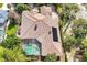 Aerial view of a tile-roofed home featuring a screened-in pool area and lush, mature landscaping at 1502 Hempel Ave, Windermere, FL 34786