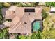 Aerial view showcases a home with a tiled roof, screened-in pool, and verdant landscaping at 1502 Hempel Ave, Windermere, FL 34786