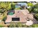 Aerial view shows home with a screened in pool, tile roof, and solar panels at 1502 Hempel Ave, Windermere, FL 34786