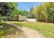 Features open backyard with grass, walkway and metal shade, offering outdoor space at 1502 Hempel Ave, Windermere, FL 34786