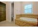 Modern bathroom featuring a large soaking tub, tiled accents, and a glass-enclosed shower at 1502 Hempel Ave, Windermere, FL 34786